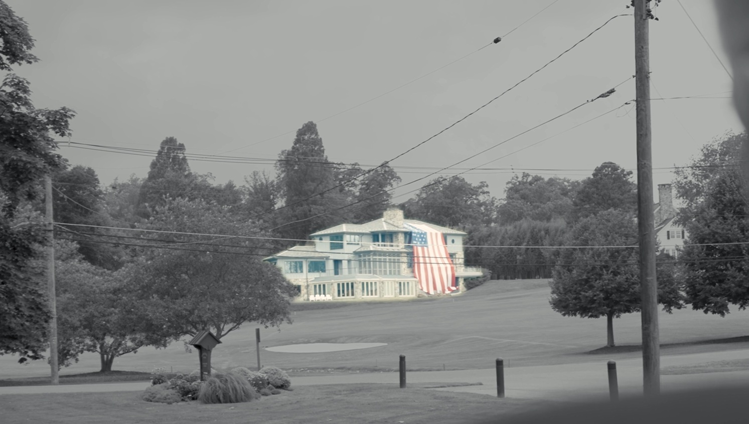 A clubhouse with a large American flag draped from the roof